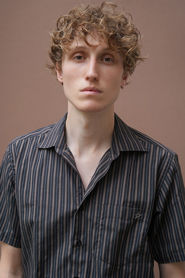 Portrait of m84this wearing a dark striped shirt